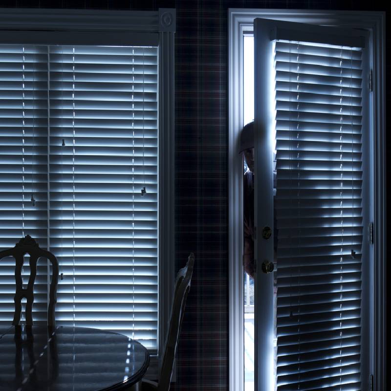 Burglar coming in the door breaking into a house at night